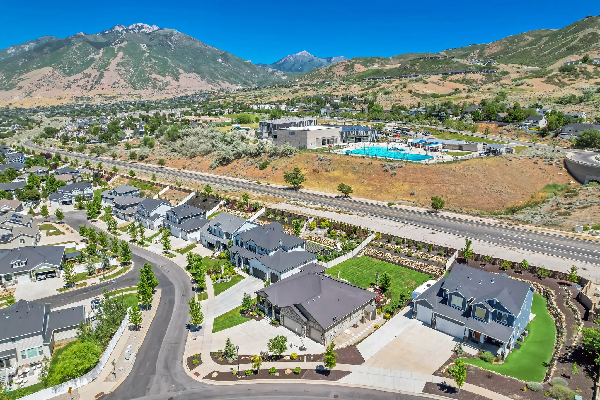 Aerial perspective featuring a residential neighborhood with paved streets and manicured landscaping