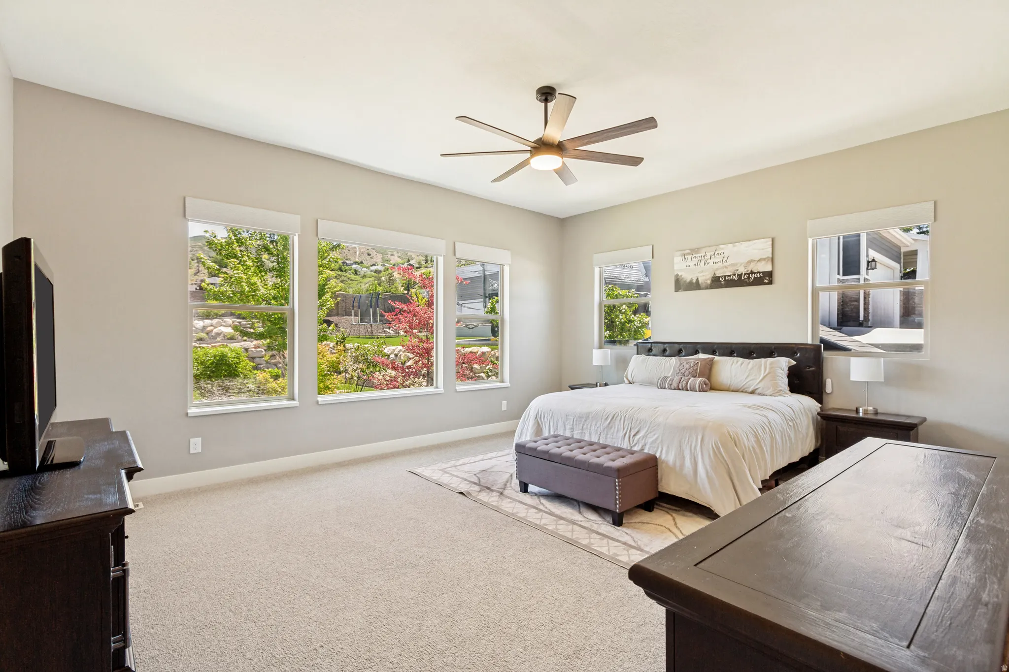 Spacious room featuring carpeting, light-toned walls, and multiple large windows