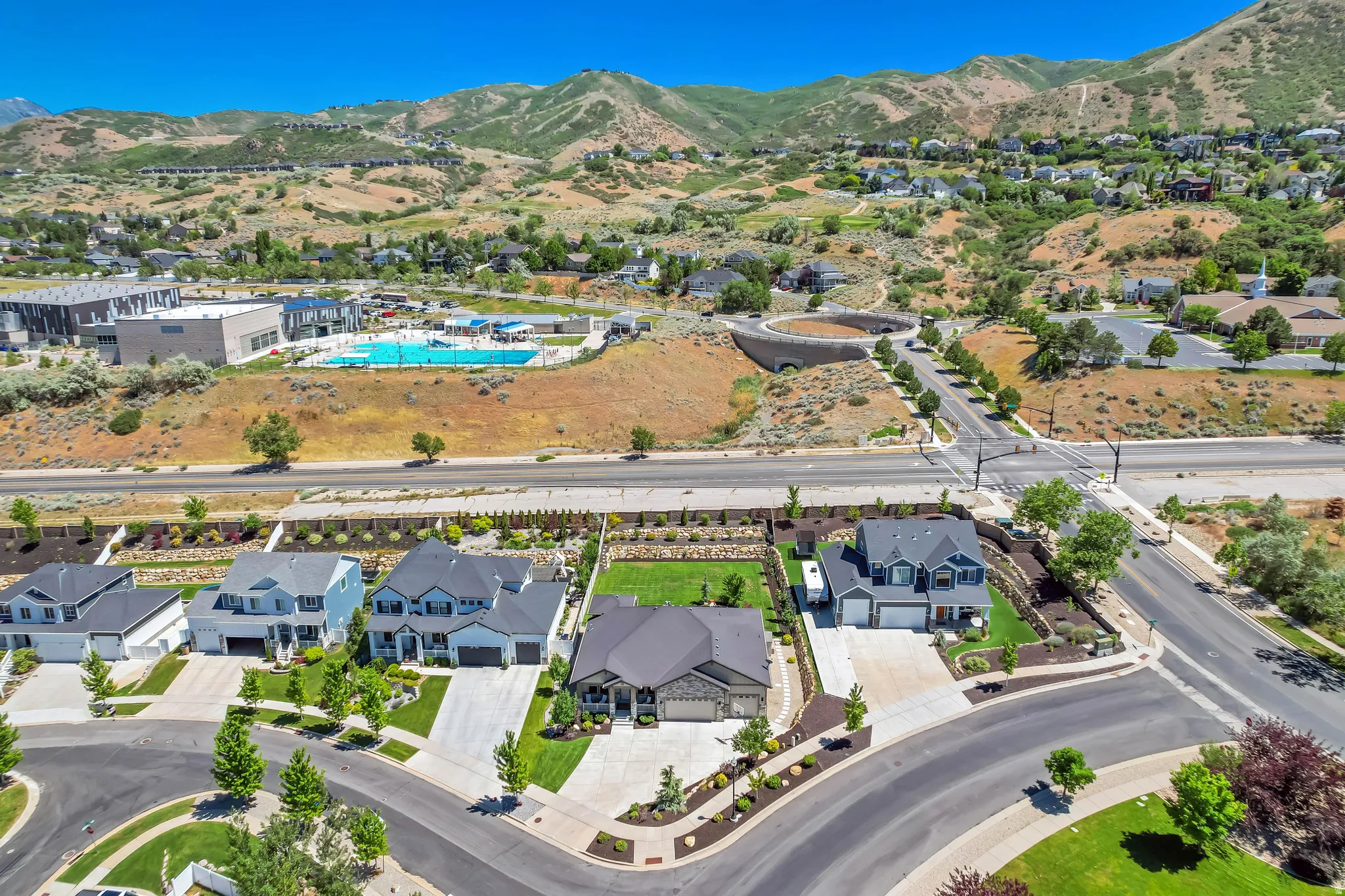 Aerial perspective showcasing a residential area with varied home styles and mountain terrain