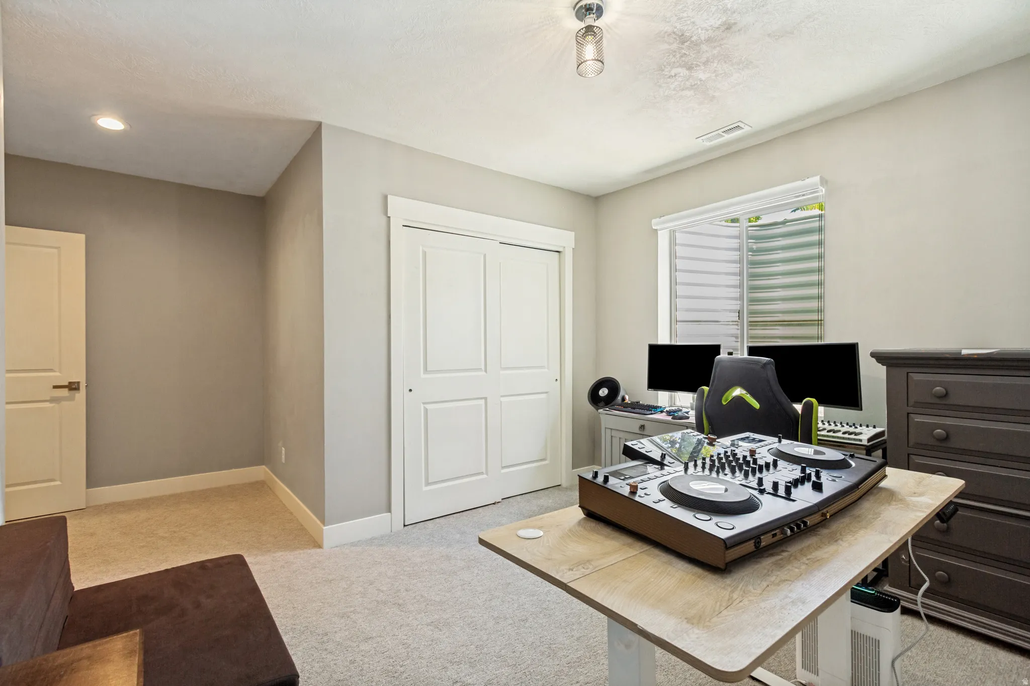 Carpeted room featuring neutral wall tones, white trim, and a white interior door