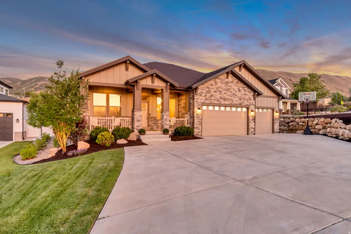 Stone and siding exterior with a covered front porch featuring white railings