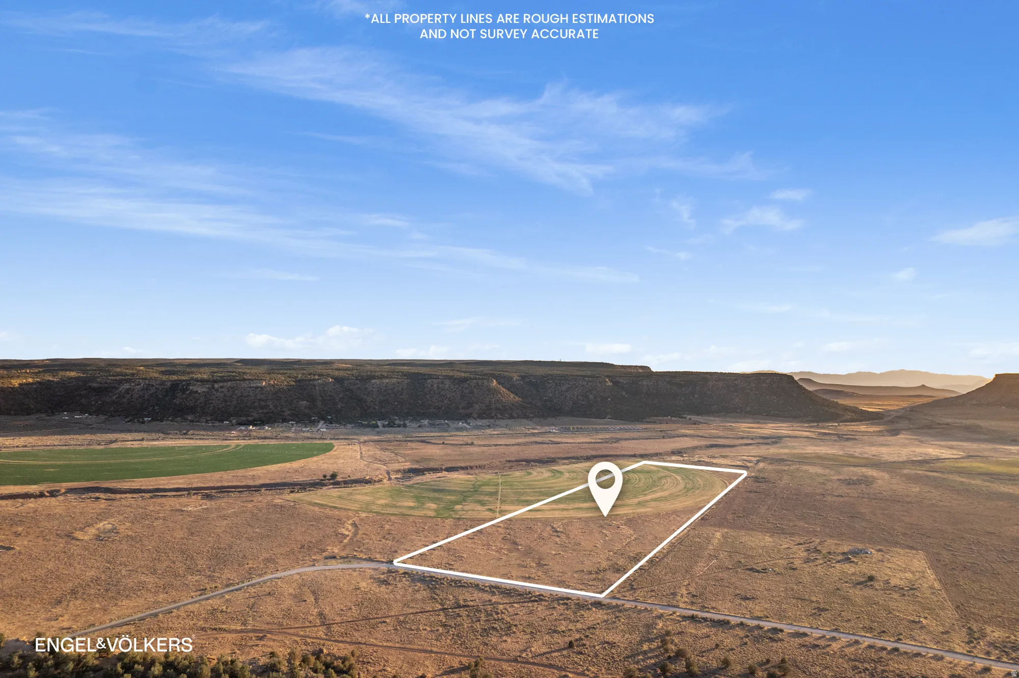 Expansive land parcel with surrounding rugged terrain and distant mesas