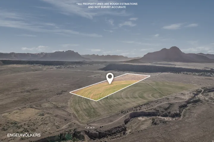 Expansive land parcel featuring a portion of cultivated fields and surrounding arid terrain