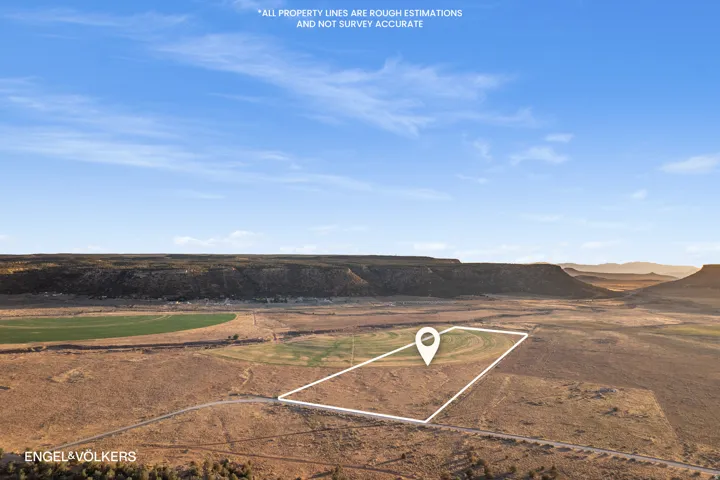 Expansive land parcel with surrounding rugged terrain and distant mesas