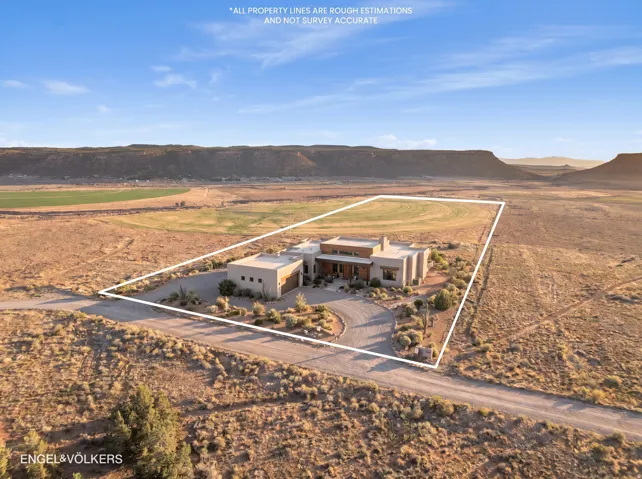 Expansive desert property featuring a contemporary stucco residence with a multi-level roofline