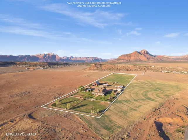 Expansive property featuring a central residence, multiple accessory buildings, and cultivated land