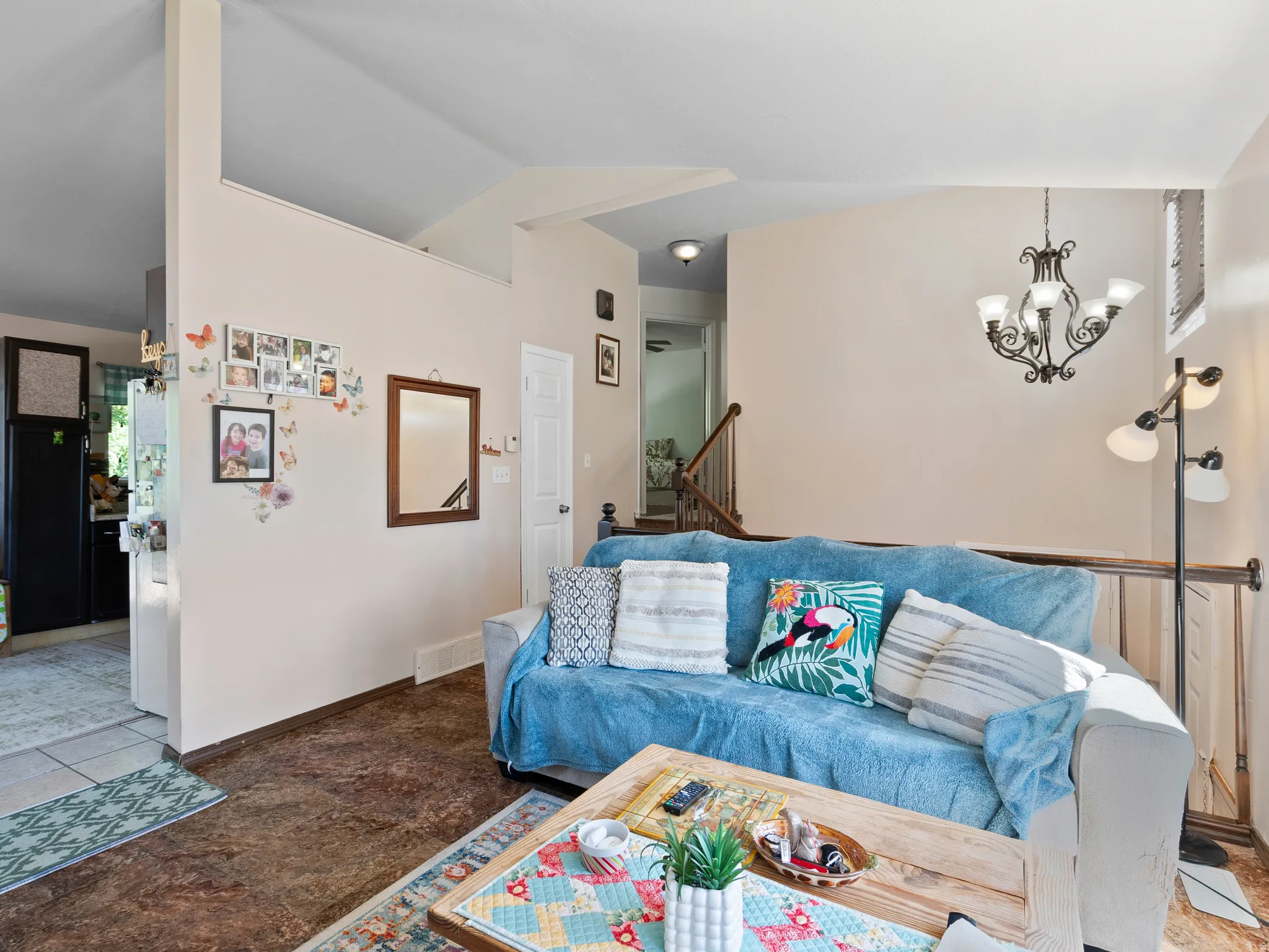 Living area featuring vaulted ceilings, a decorative chandelier, and wood-finish flooring