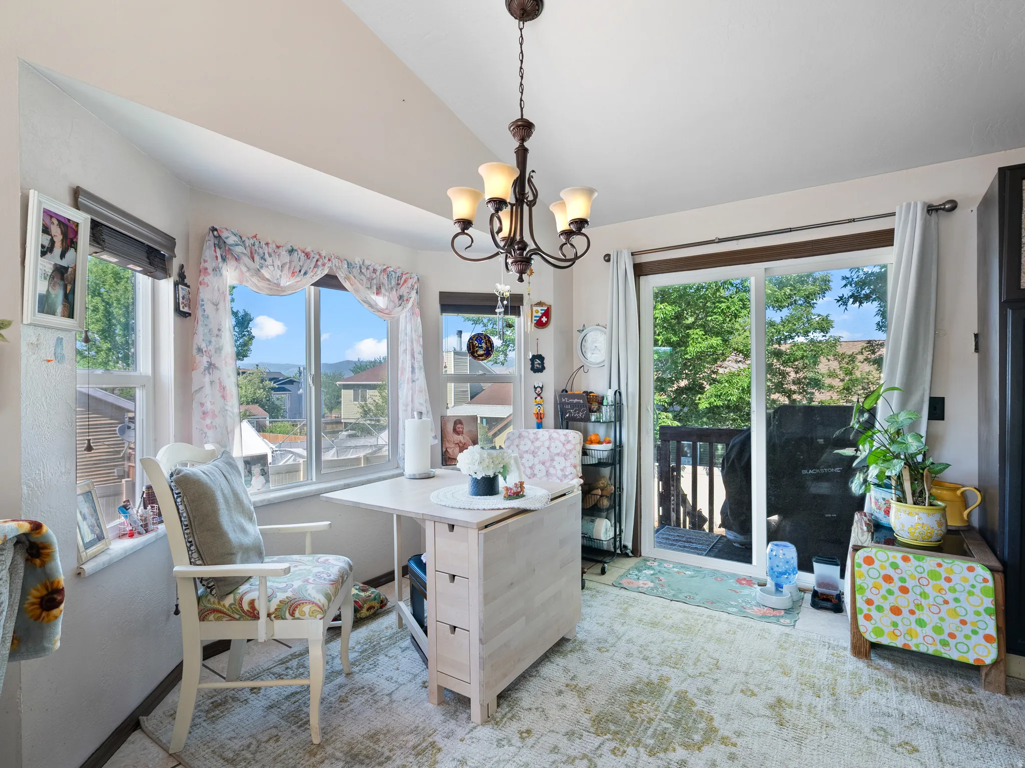 Dining area featuring a chandelier, bay window, sliding glass door, and wood-finish flooring