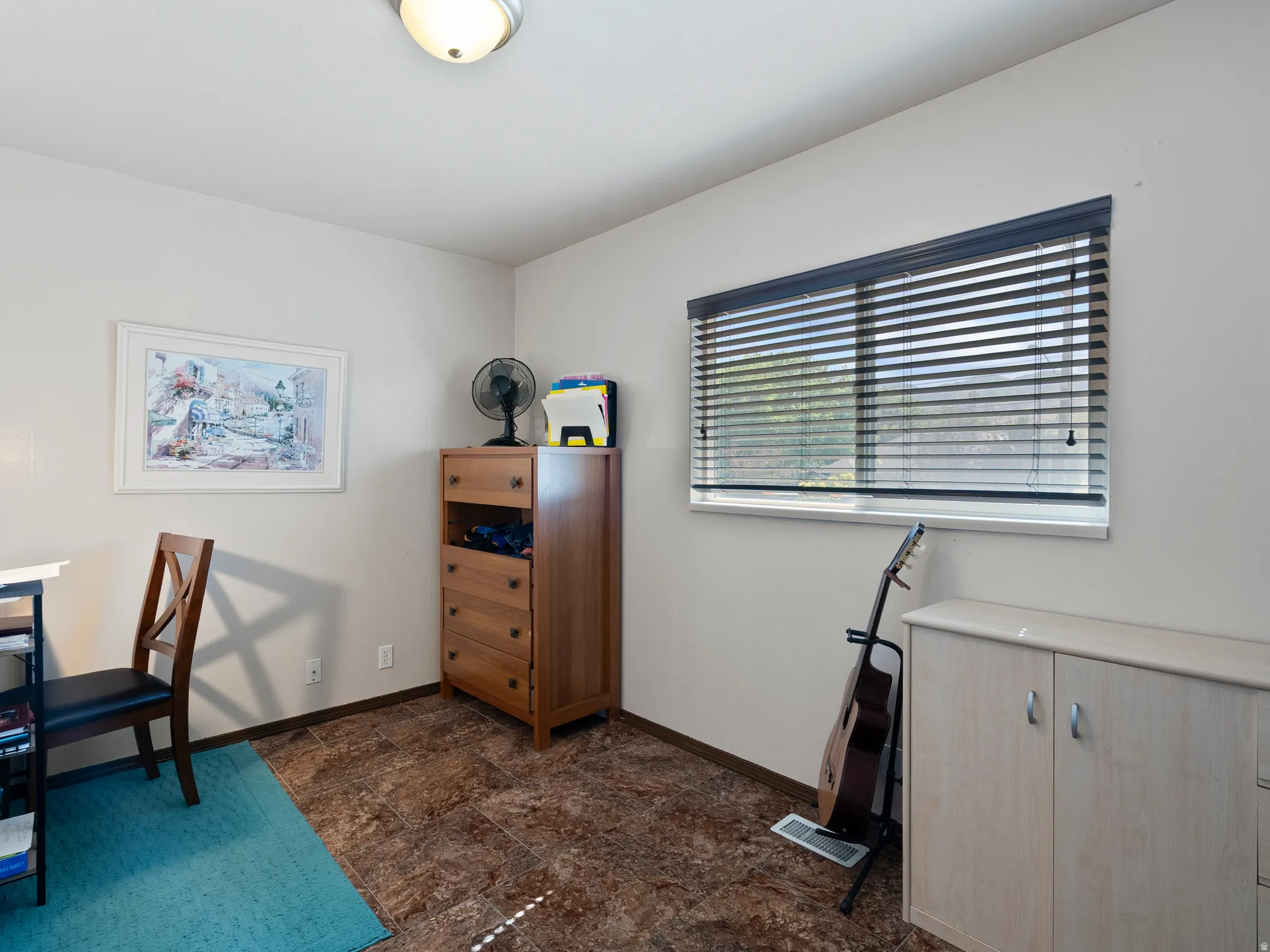 Room featuring textured flooring, a window with horizontal blinds, and a flush mount ceiling light