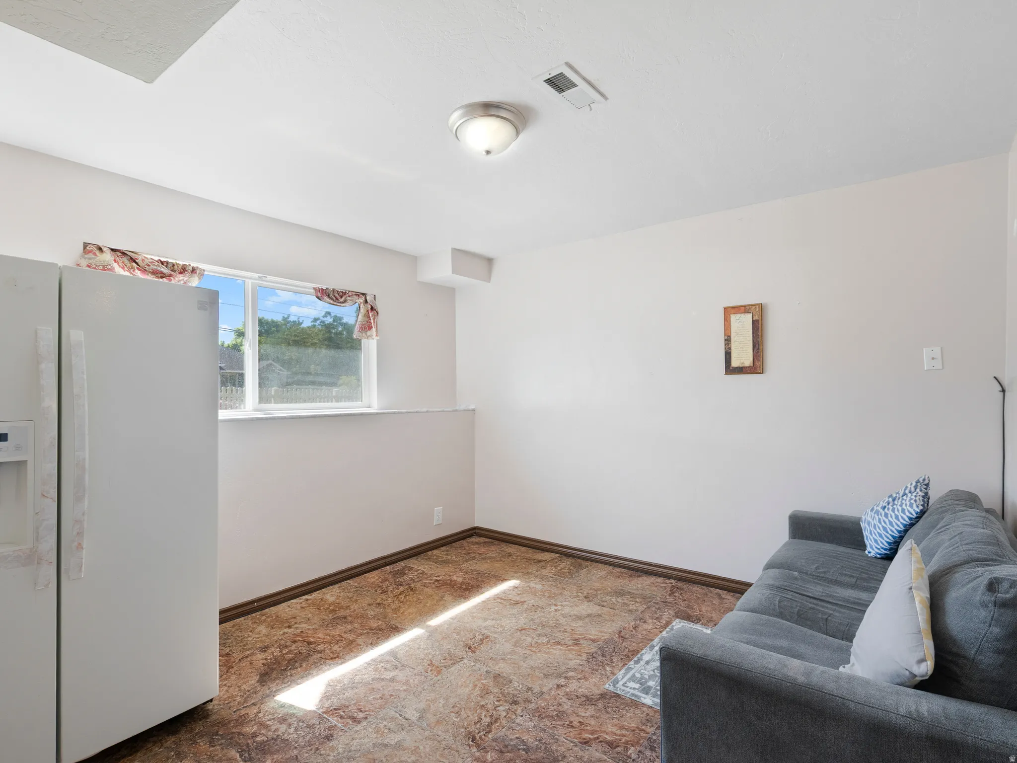 Interior space featuring light-toned walls, a window with exterior views, and a ceiling-mounted light fixture