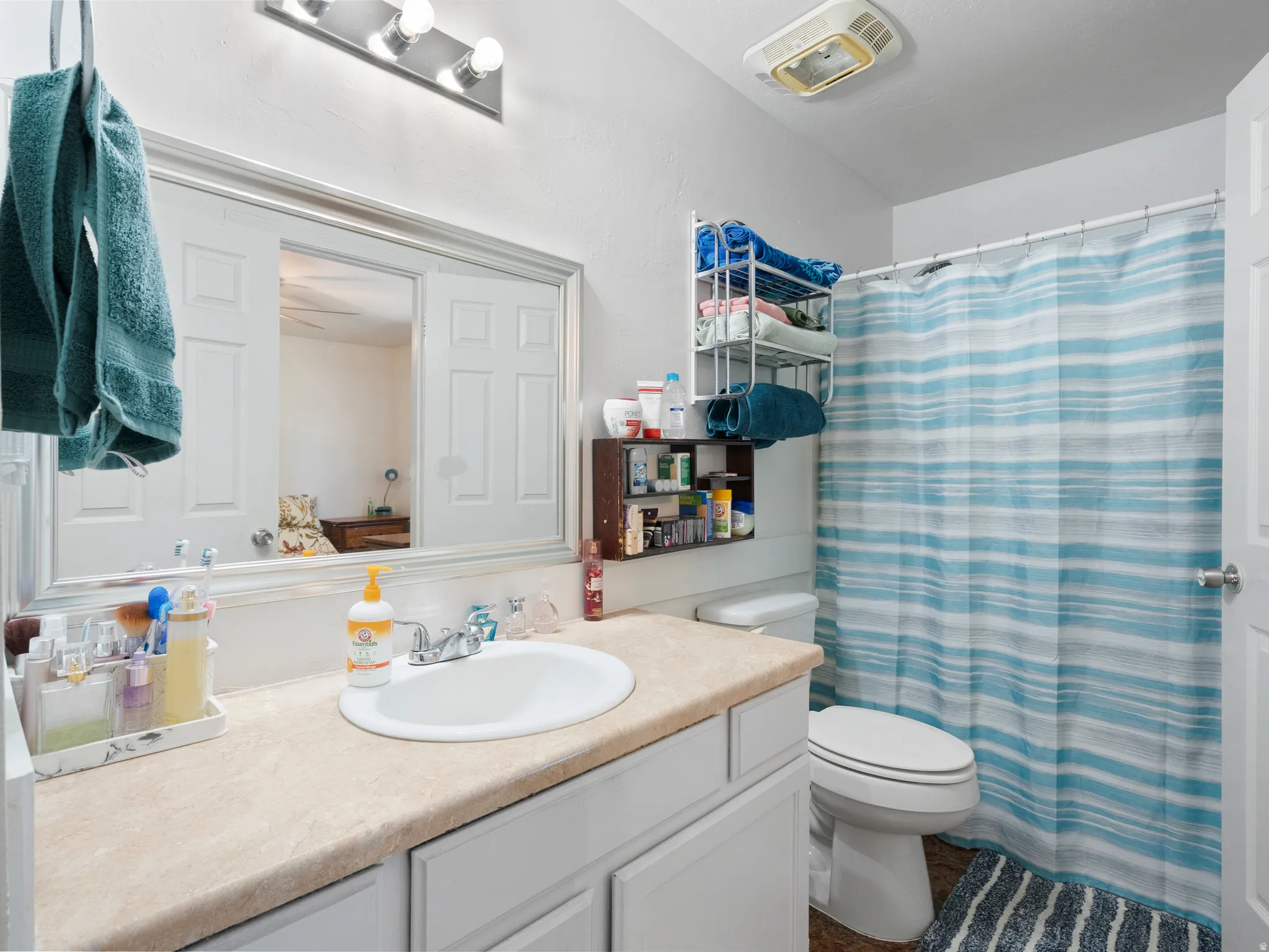 Bathroom vanity with a light-toned countertop, integrated sink, and chrome faucet