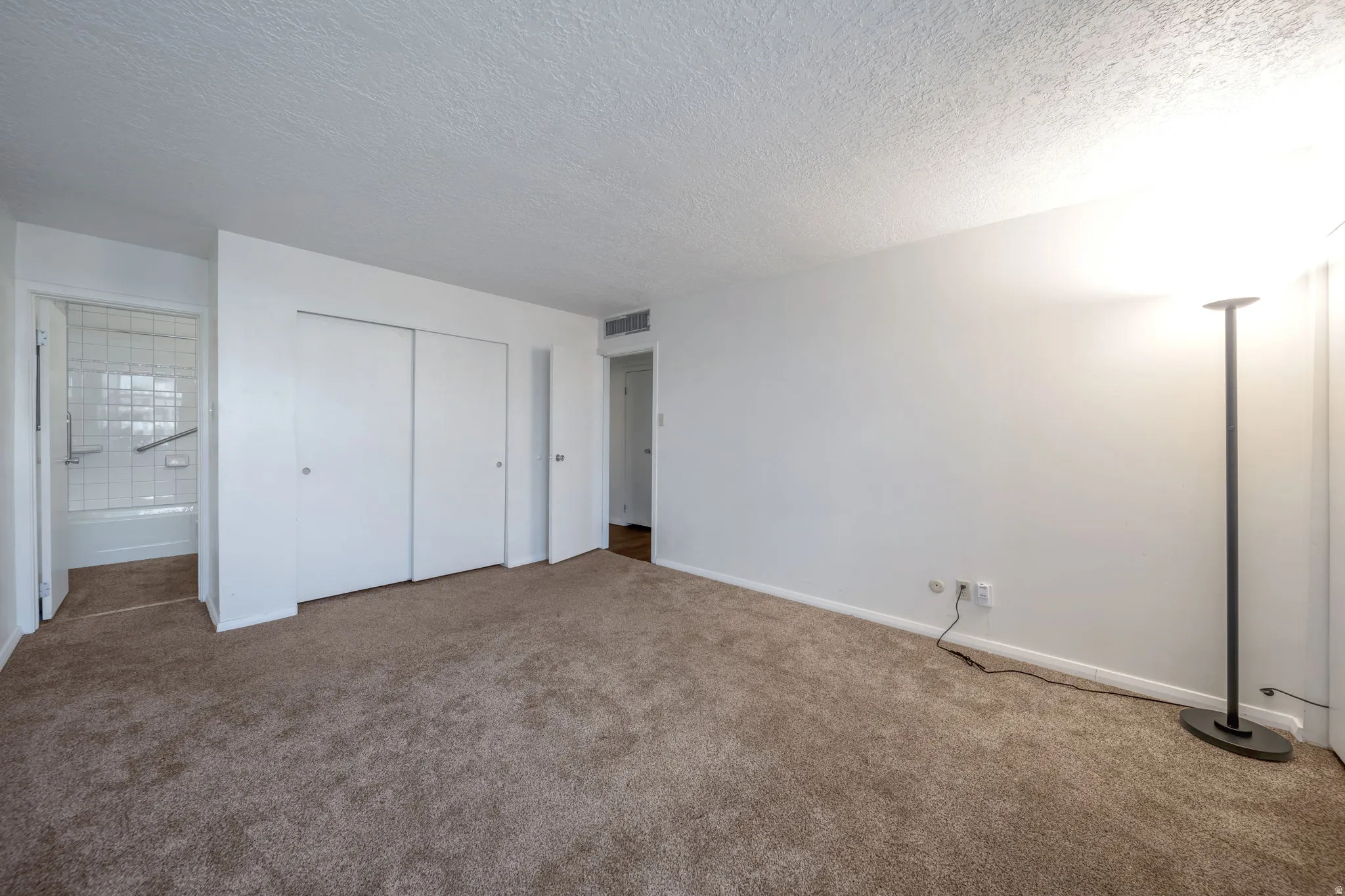 Spacious room with plush brown carpet flooring and white walls
