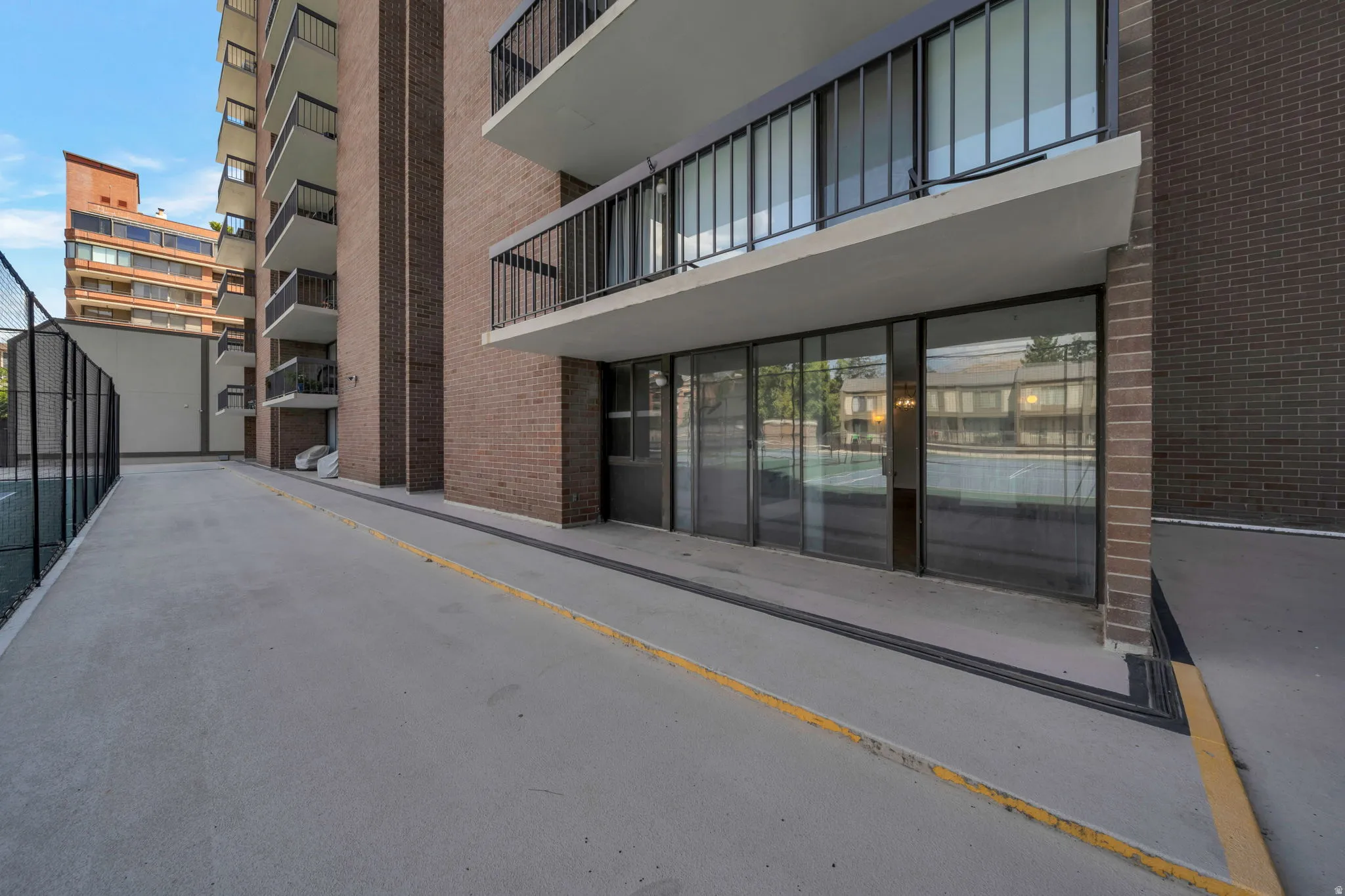 Brick exterior high-rise building featuring multiple levels of private balconies with black metal railings