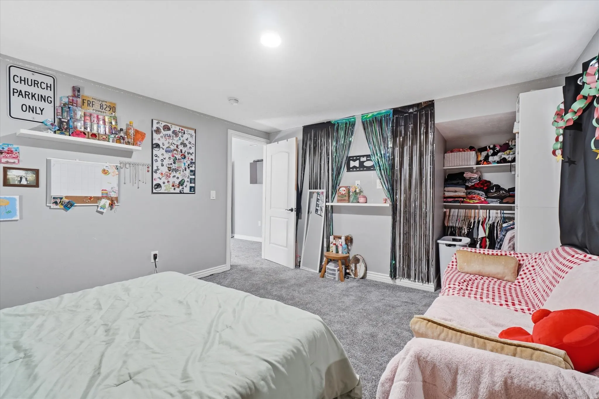 Carpeted bedroom featuring light gray walls, white trim, and a white six-panel interior door