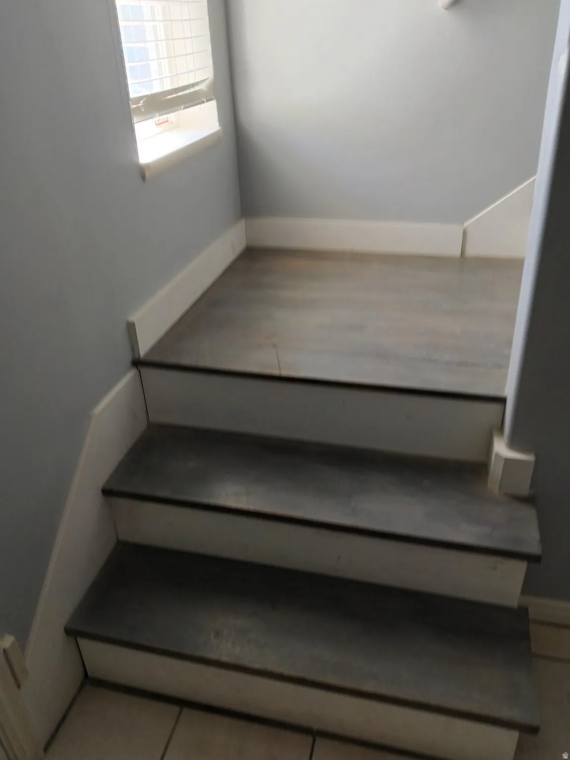 Staircase featuring wood-finish treads and white risers
