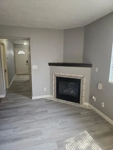 Corner fireplace with decorative tile surround and dark wood mantel