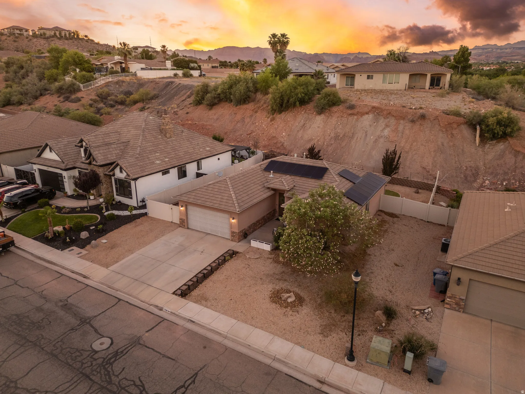 Contemporary stucco residence with stone accents, a two-car garage, and a tiled roof