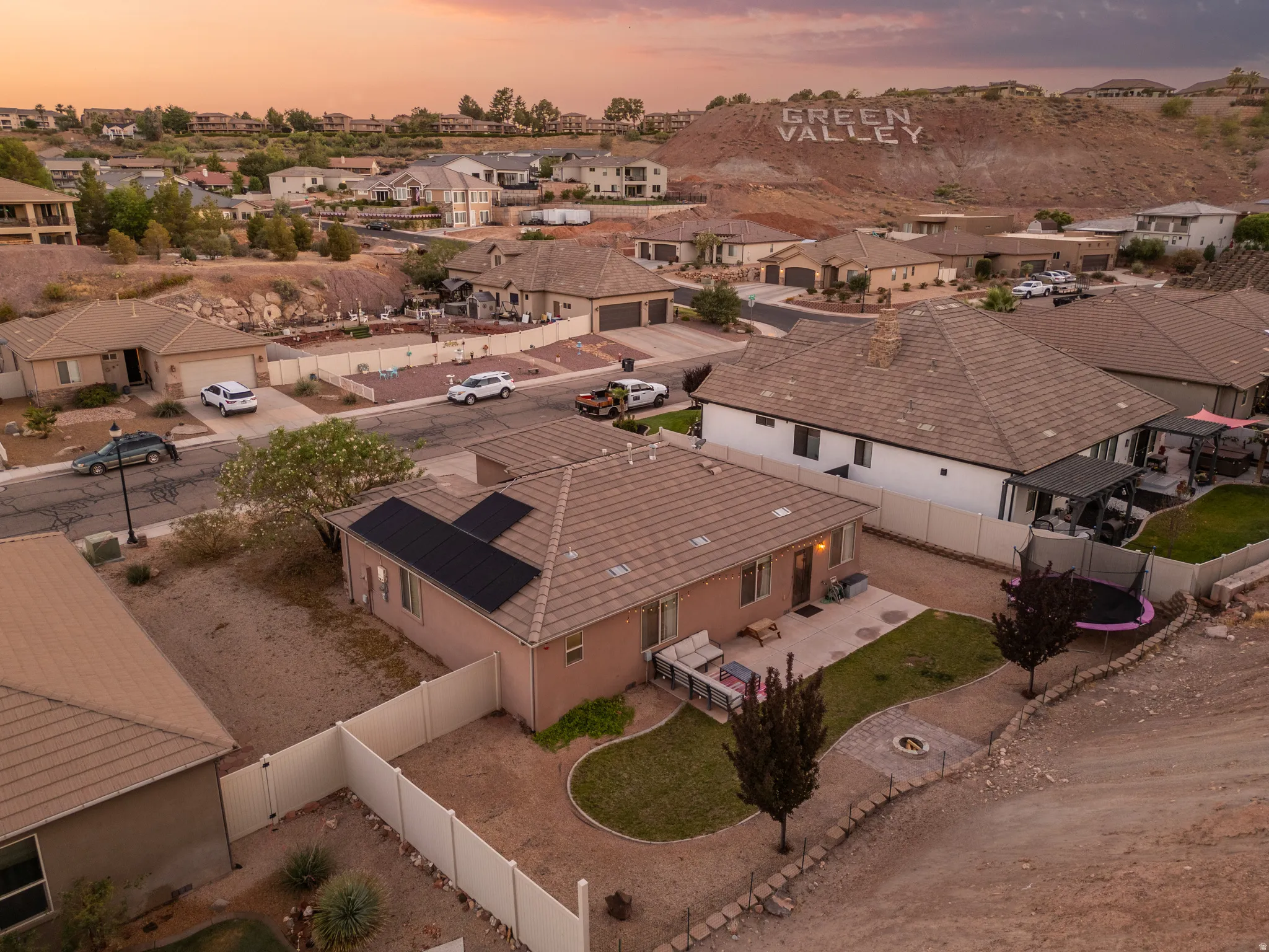 Residential property featuring a stucco exterior, tile roof, and solar panels