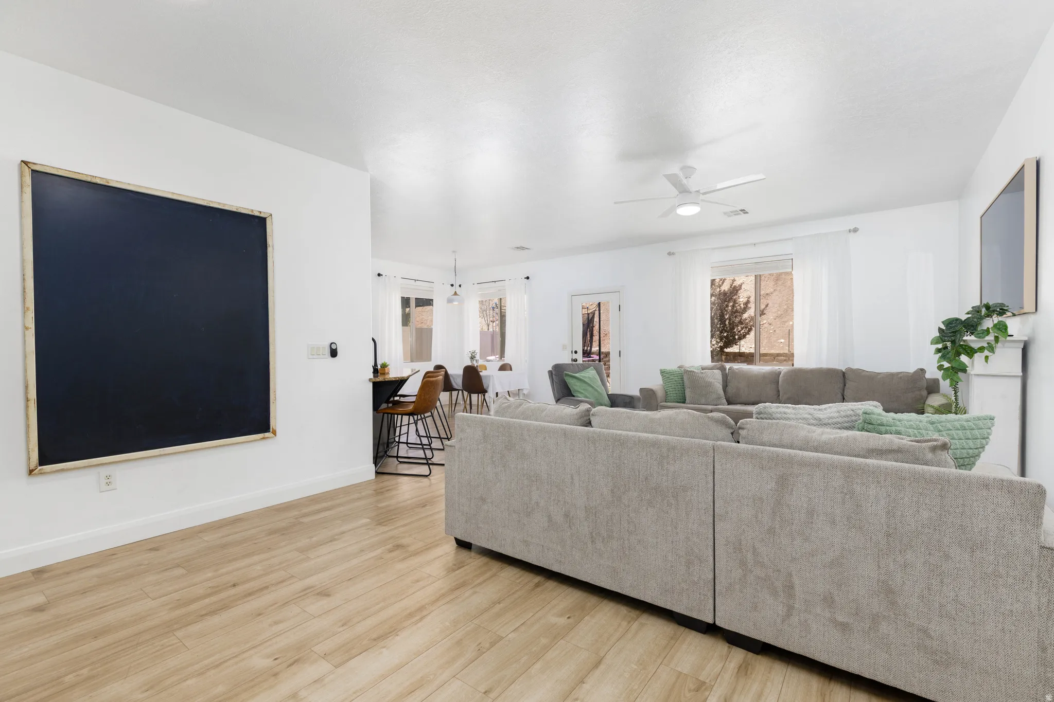Spacious gathering room featuring light wood-finish flooring and white walls