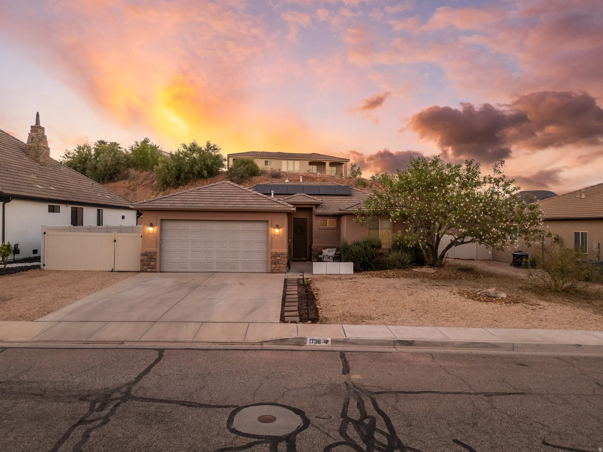 Single-story residence featuring an attached two-car garage, tile roofing, and stone facade accents