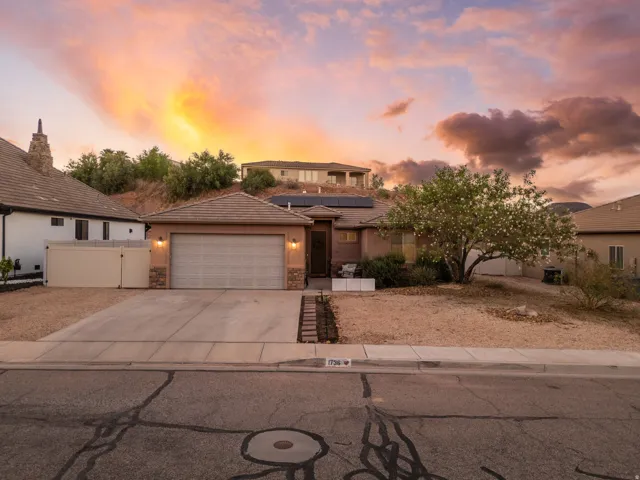Single-story residence featuring an attached two-car garage, tile roofing, and stone facade accents