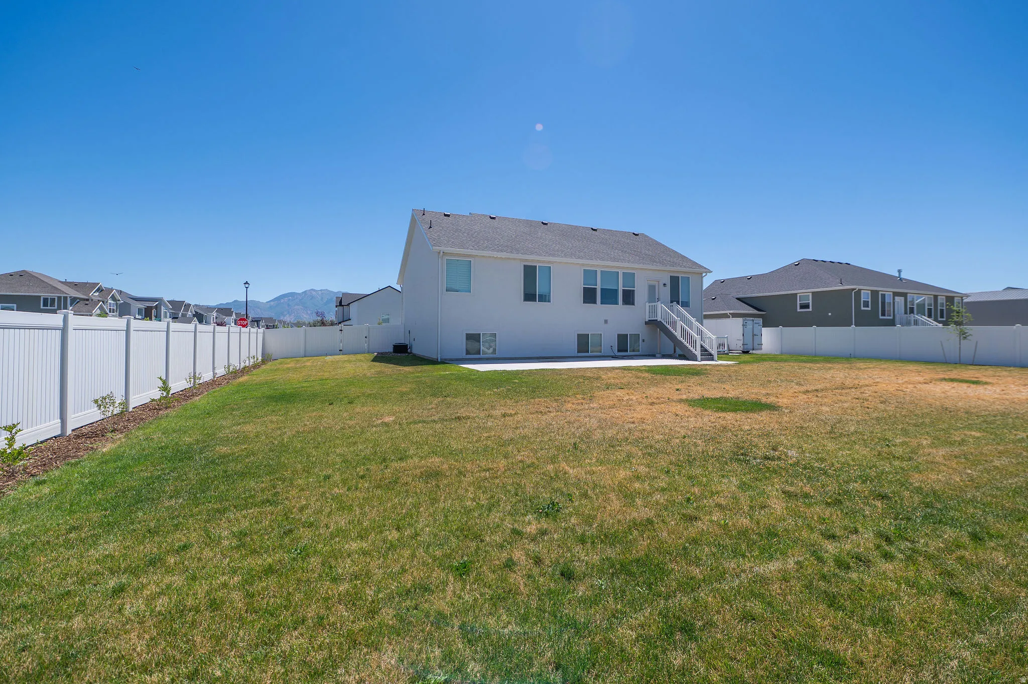 Expansive backyard featuring a white vinyl fencing