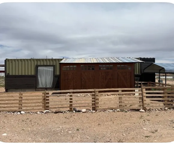 Property exterior featuring a shipping container structure with an attached shed