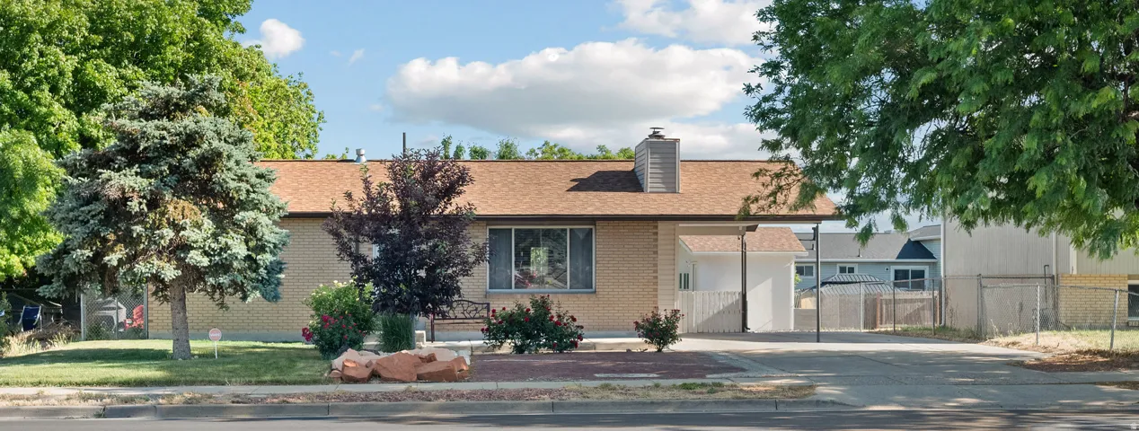Single-story residence featuring light-colored brick siding, an asphalt shingle roof, and a prominent front-facing window