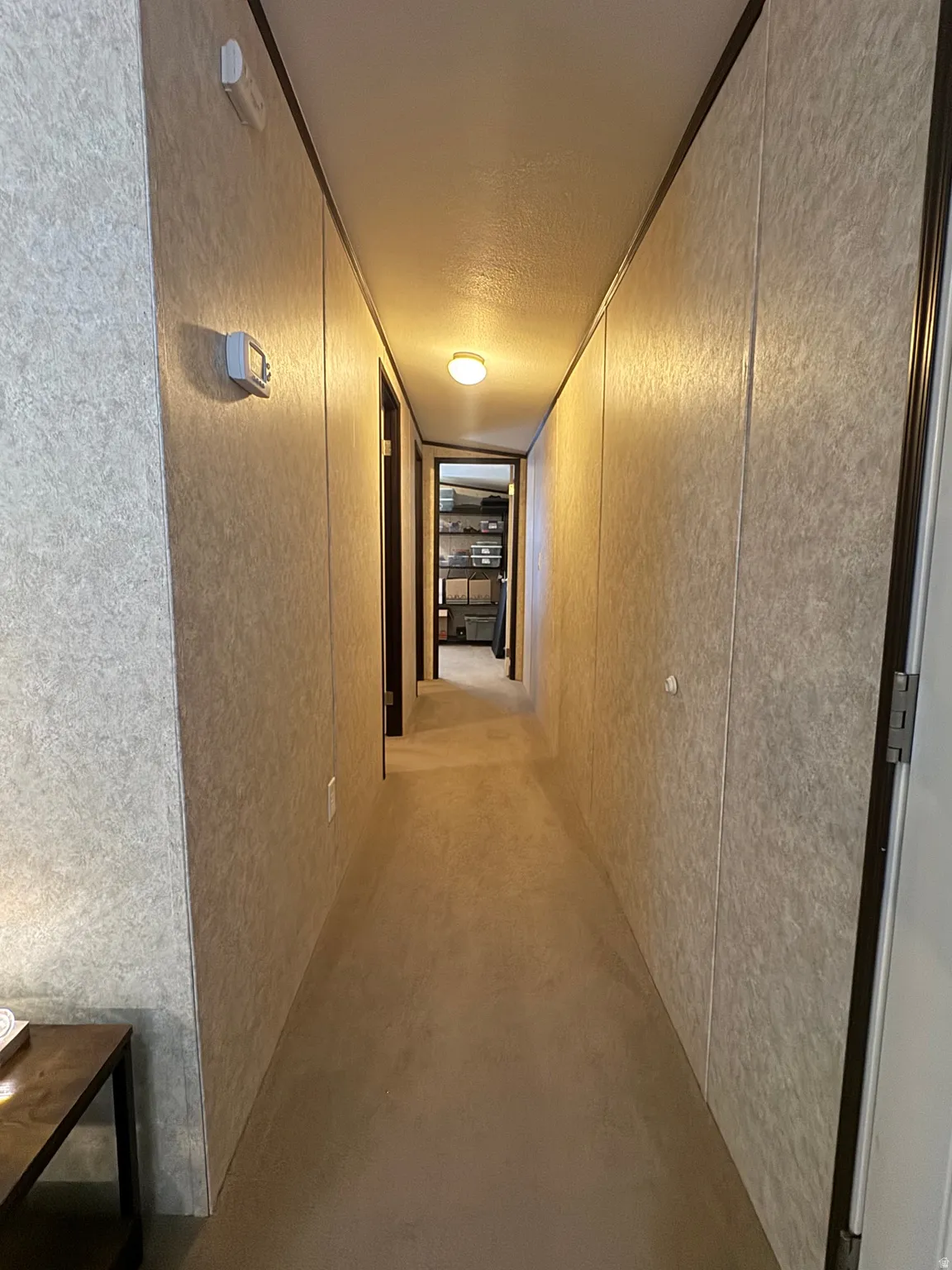 Hallway featuring carpet flooring and paneled walls with contrasting trim
