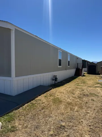 Single-story residence featuring light gray vertical siding and white trim