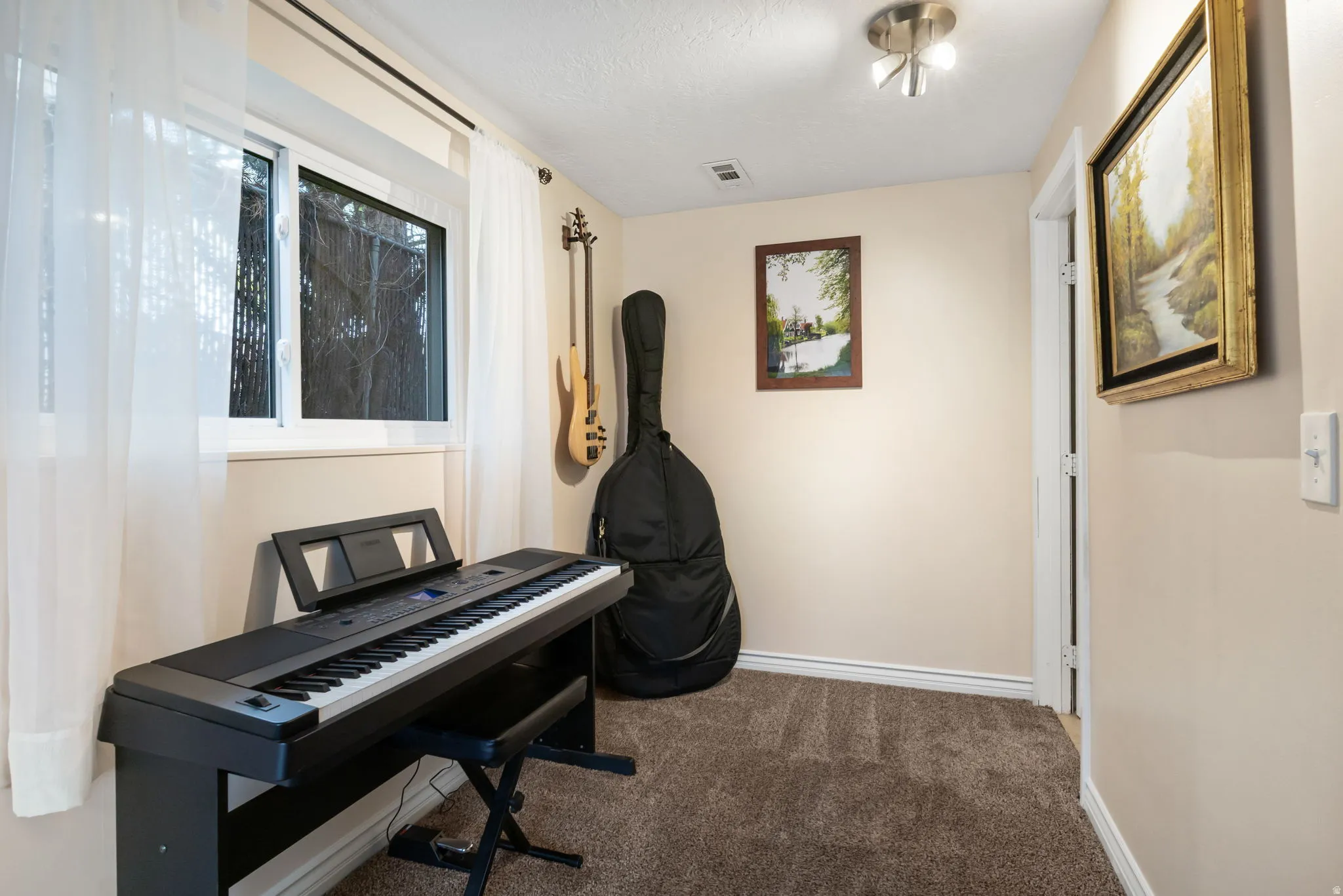 Carpeted room featuring a double-pane window, neutral-toned walls, white baseboards, and a flush-mount ceiling light fixture