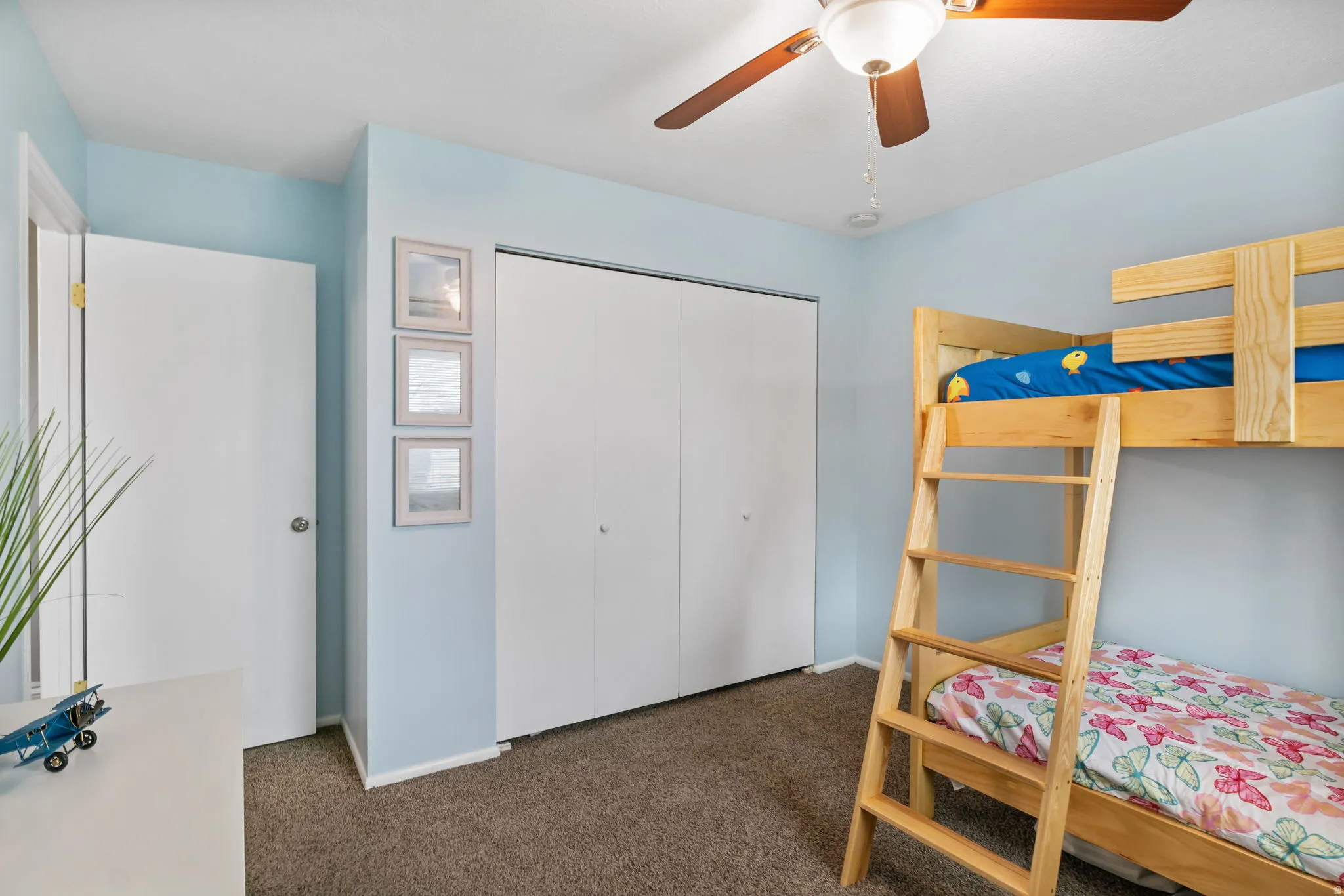 Bedroom featuring light blue painted walls and a textured brown carpet