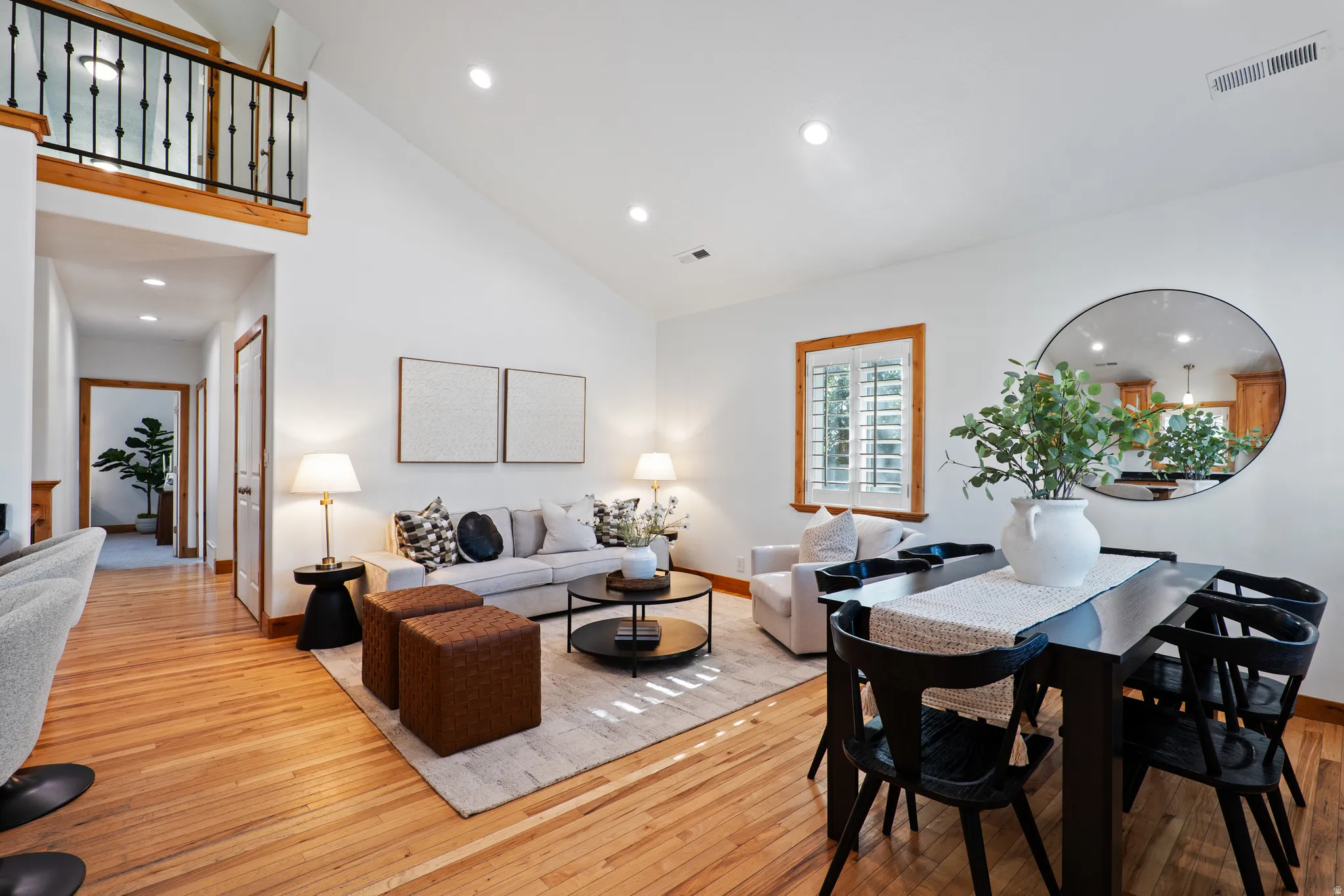 Spacious living area featuring high vaulted ceilings, recessed lighting, and rich wood-finish flooring