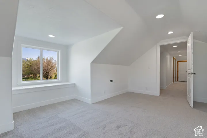 Carpeted room with a window seat, recessed lighting, and a white paneled door