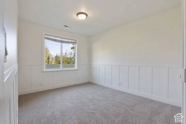 Carpeted room featuring a double window, white trim, and a ceiling-mounted light fixture