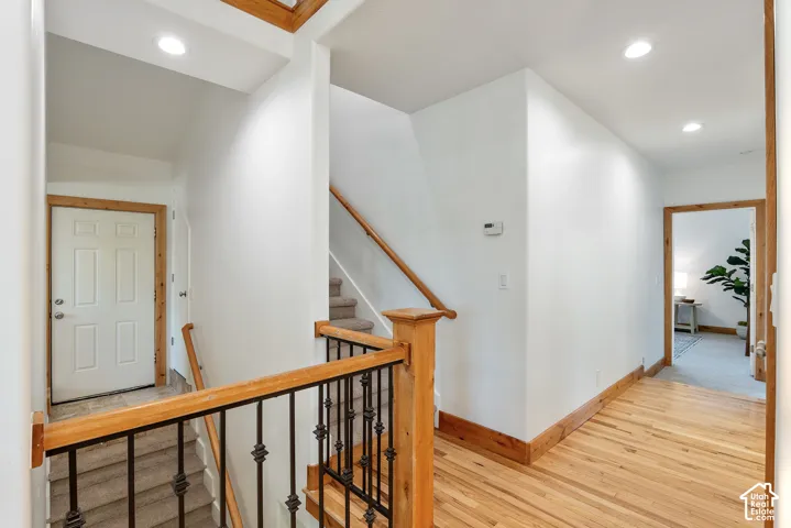 Hallway featuring light wood-finish flooring and white walls