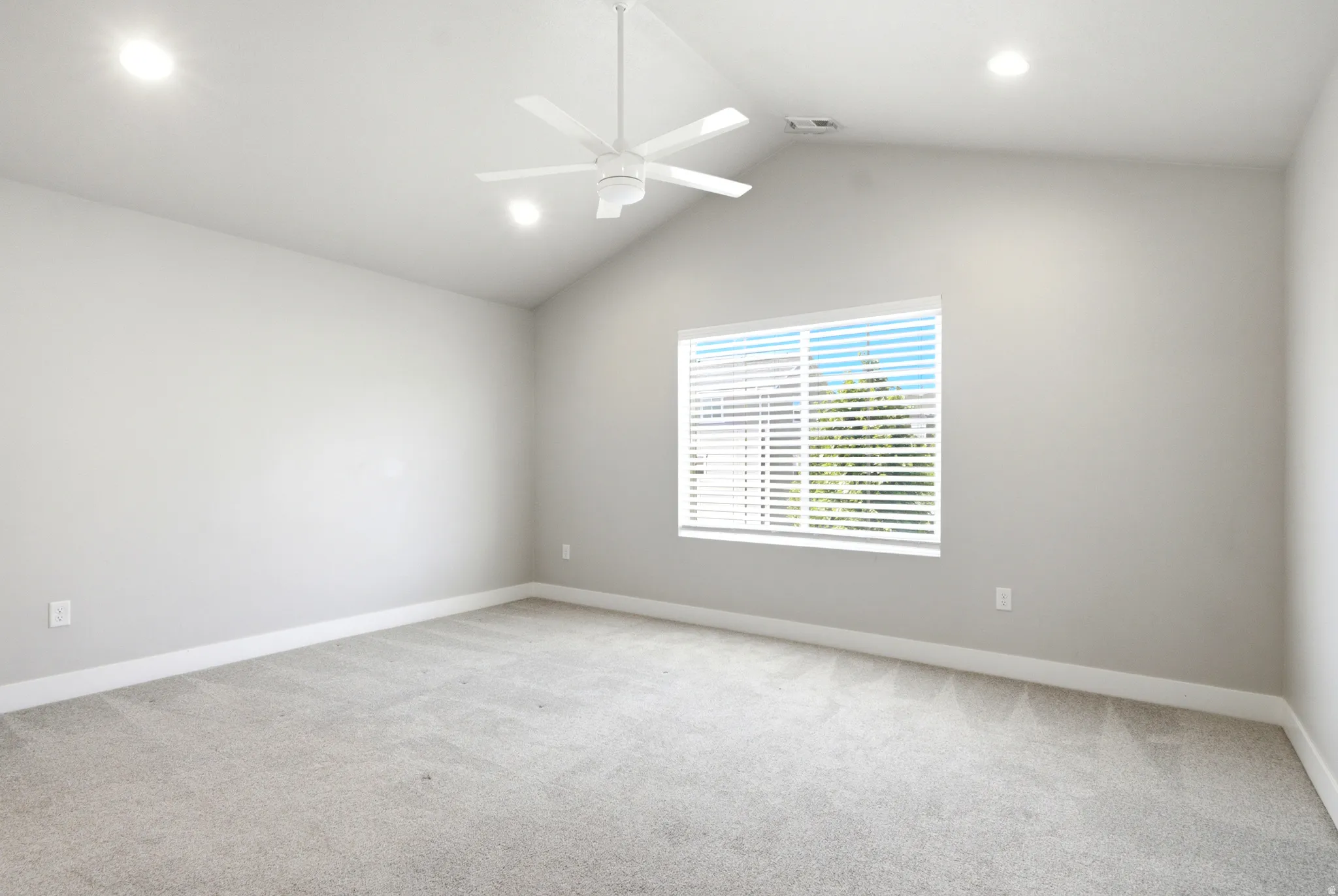 Vaulted ceiling room with recessed lighting, ceiling fan, and light gray wall paint