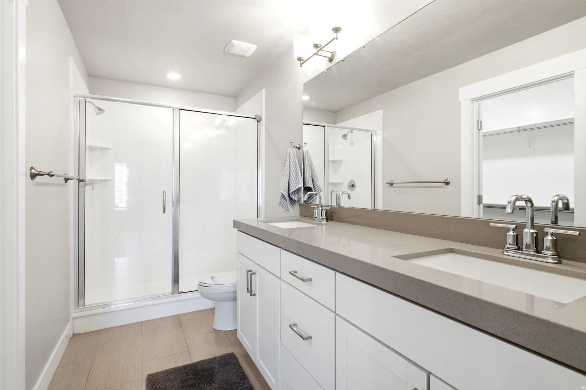 Bathroom featuring a double vanity with an integrated countertop and two undermount sinks