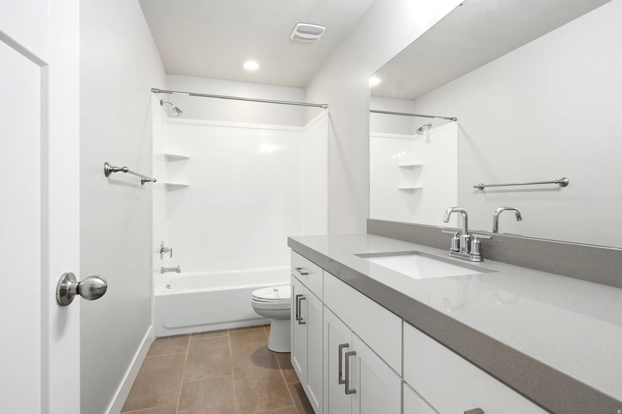 Modern bathroom featuring a single vanity with a light gray countertop, undermount sink, and chrome faucet
