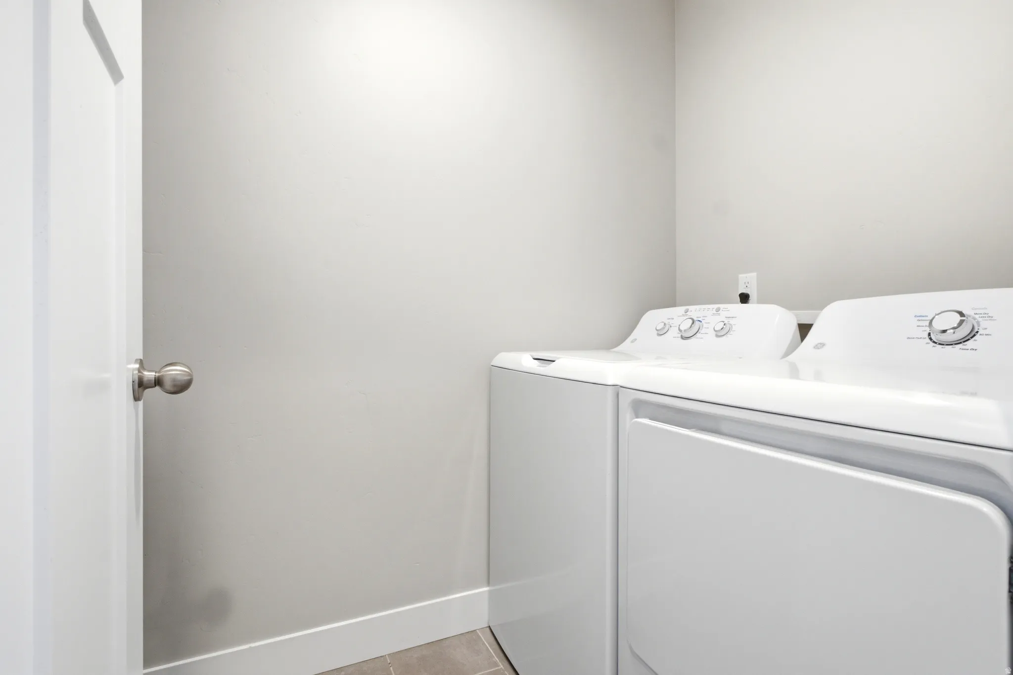 Dedicated laundry space featuring a white top-load washing machine and front-load dryer