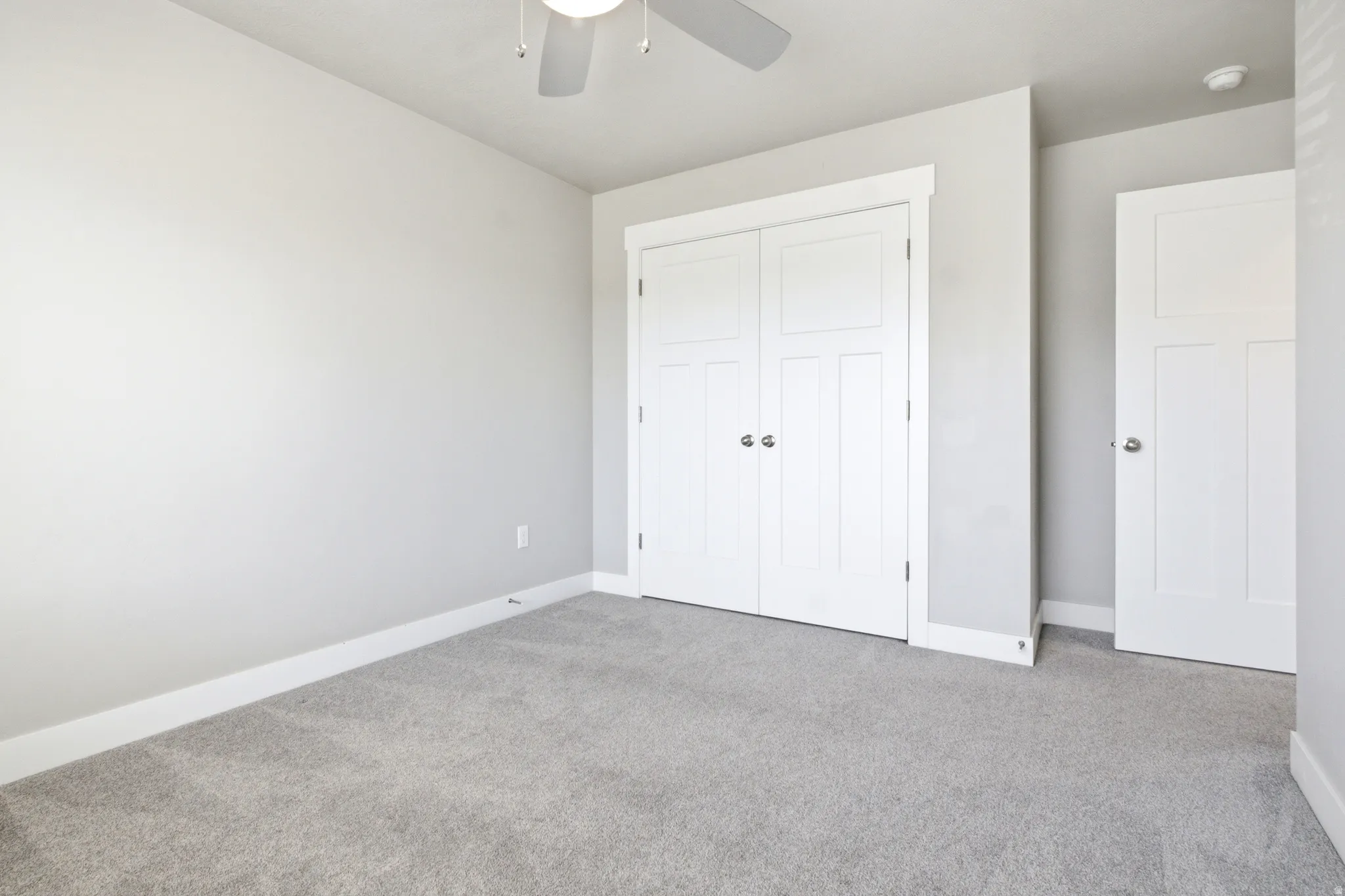 Light gray wall paint complemented by white trim and a neutral carpet