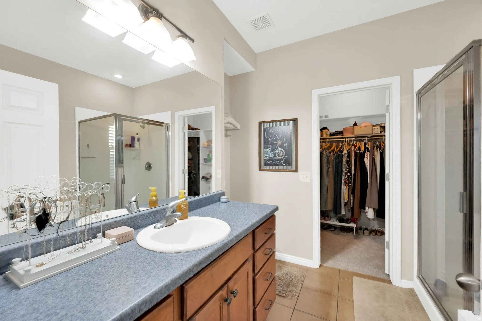 Bathroom vanity featuring an oval sink, single-handle faucet, and wood-finish cabinetry