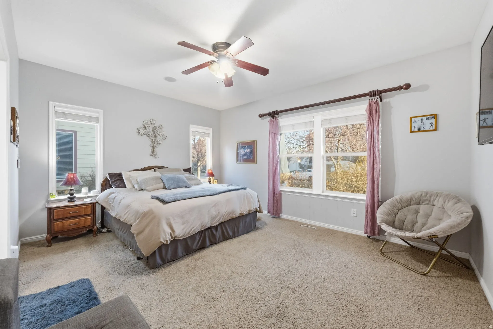 Spacious bedroom featuring light neutral wall tones and plush carpeting