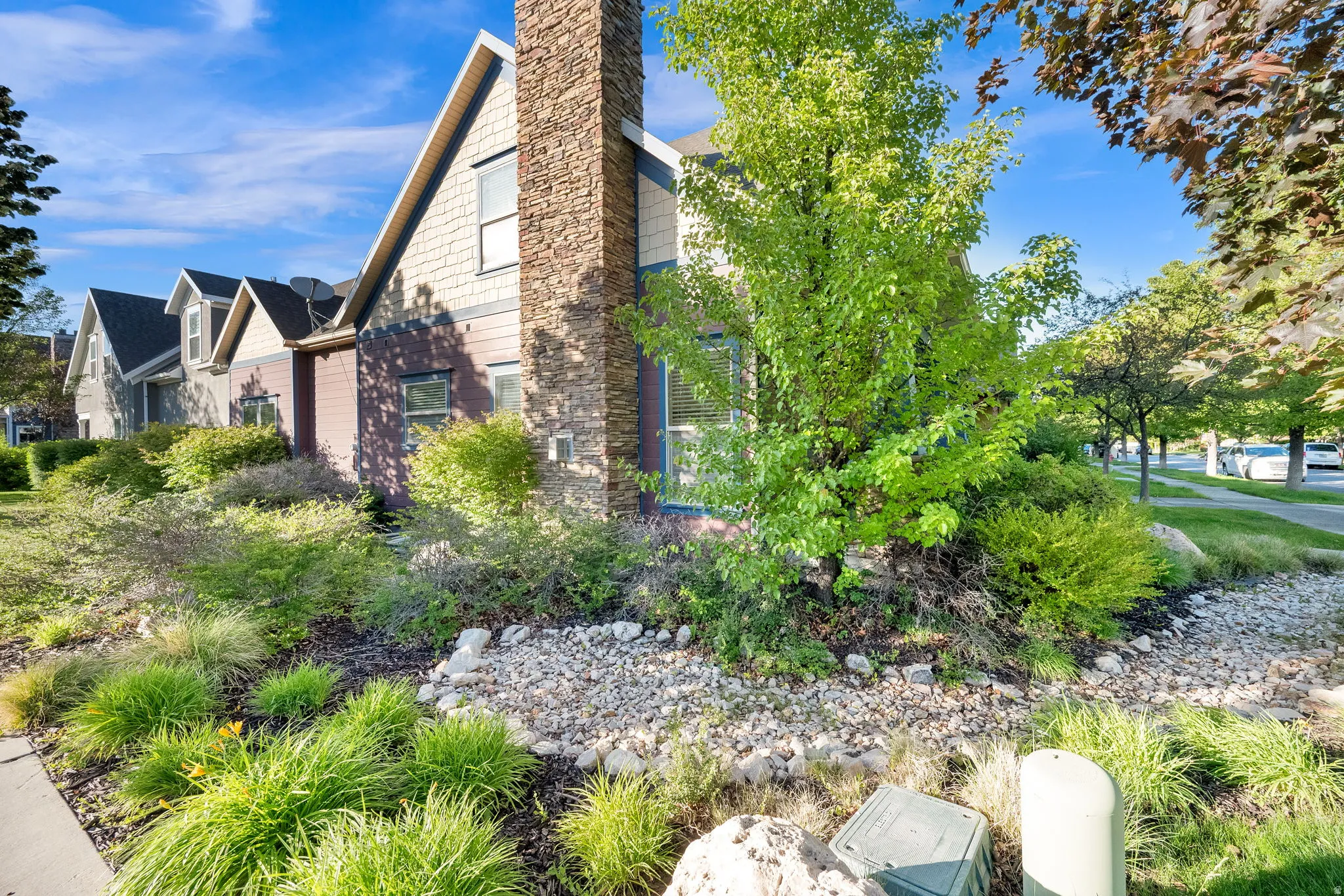 Exterior featuring varied siding, a prominent stone chimney, and gable rooflines