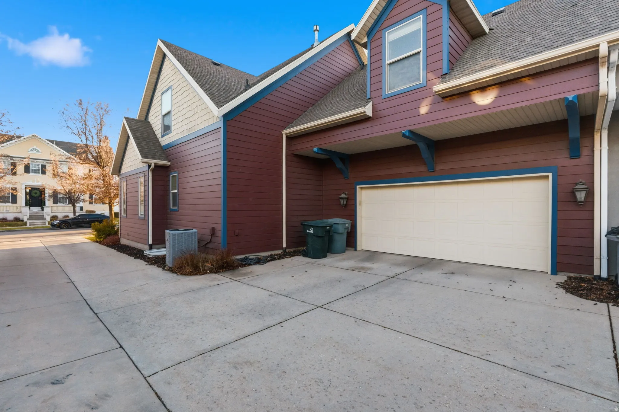 Property exterior featuring a multi-tone facade with red siding and light-colored upper-level siding