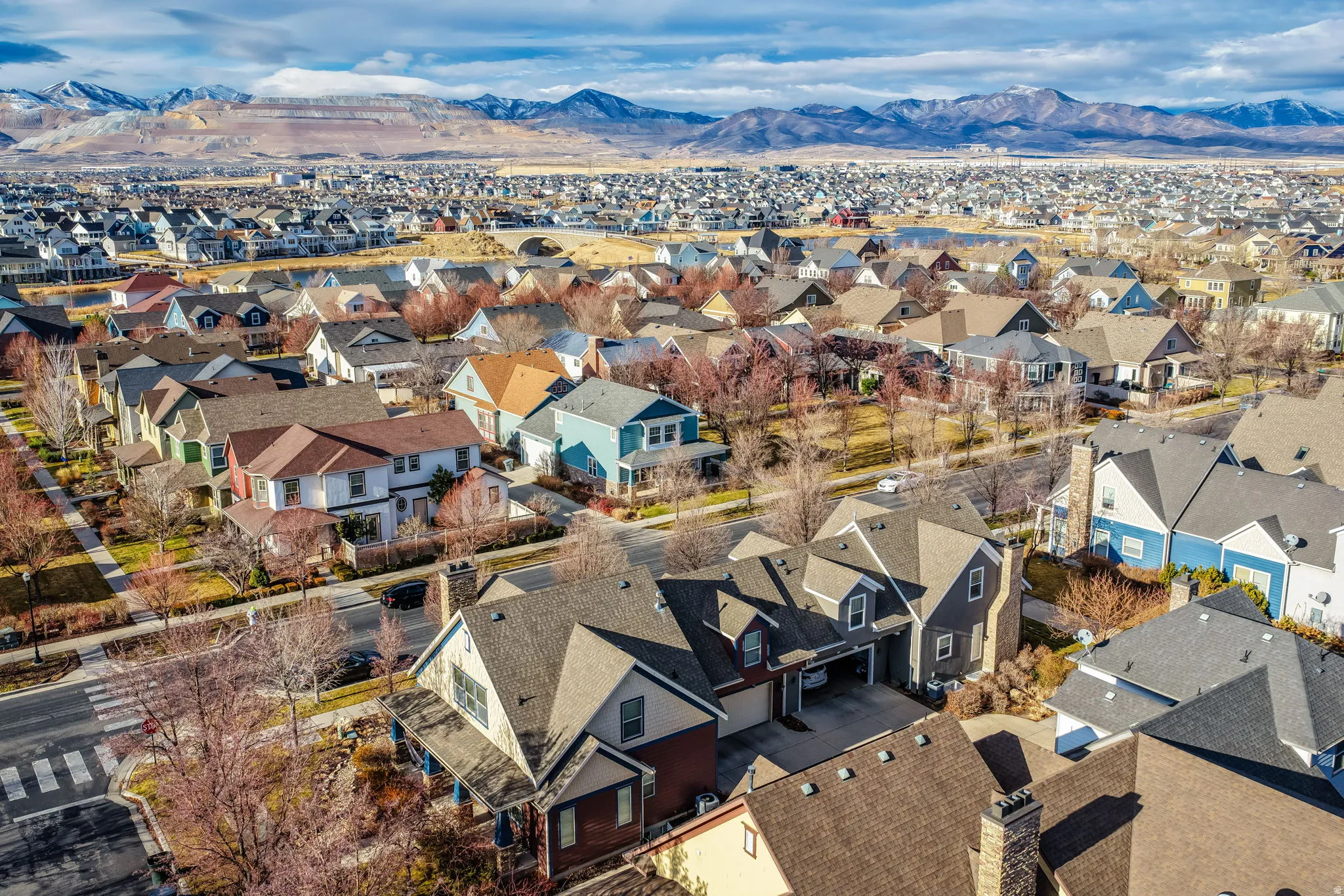 Residential neighborhood featuring varied architectural styles and mature landscaping, set against a backdrop of distant mountains
