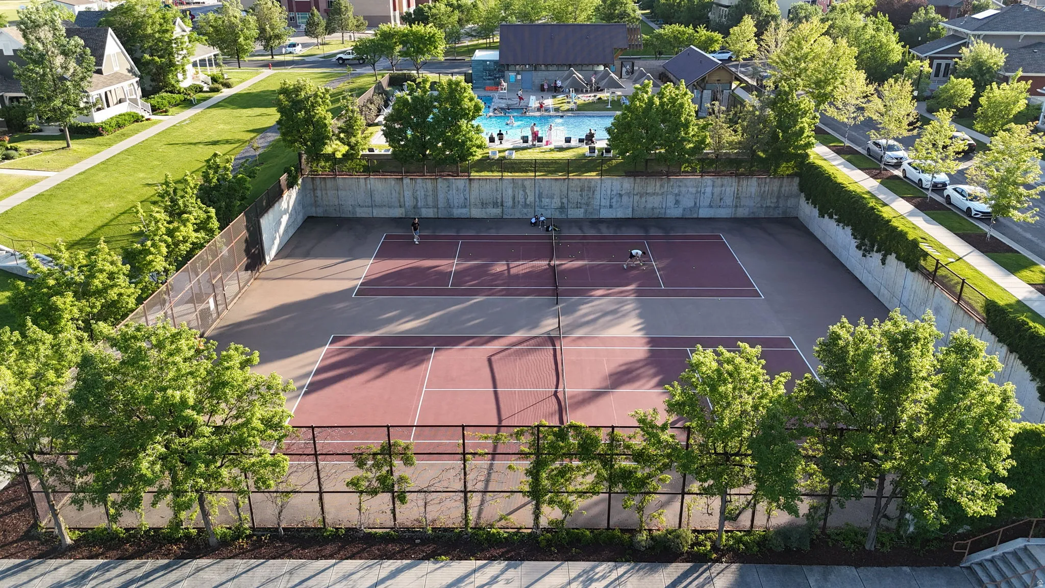 Dual tennis courts with red and gray surfaces