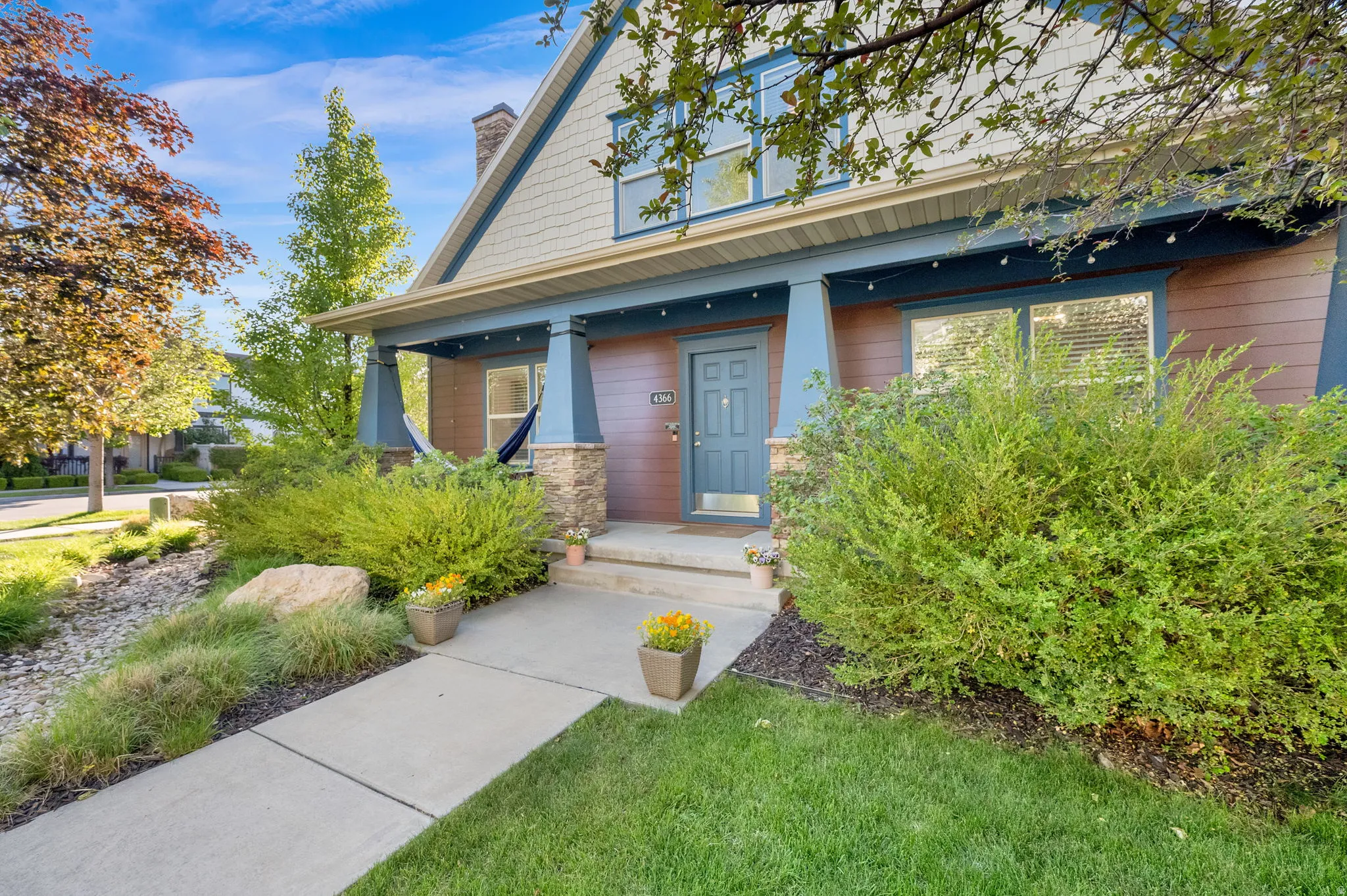 Craftsman-style exterior with a covered front porch featuring stone-clad columns