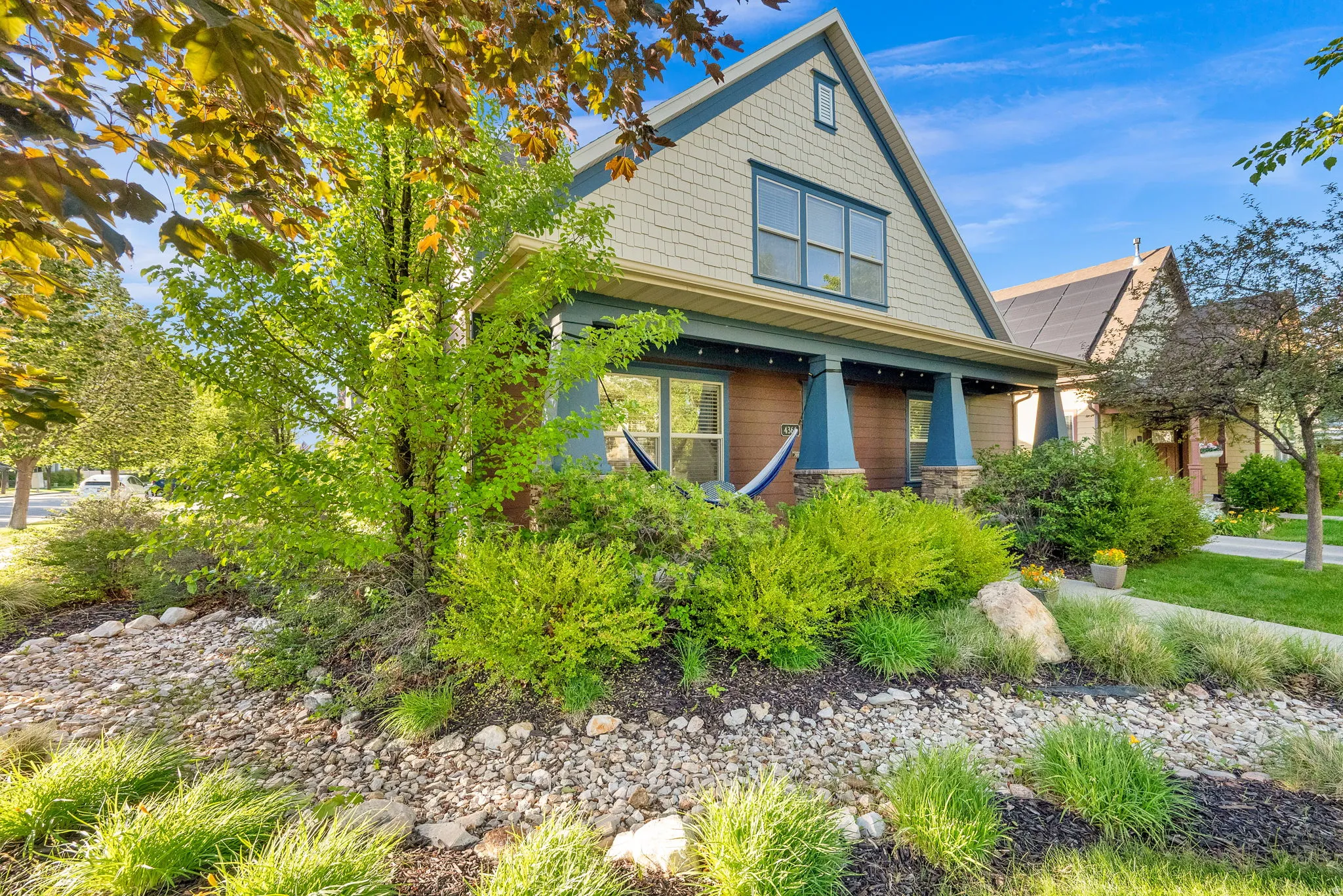 Craftsman-style home featuring a covered front porch with stone-wrapped columns