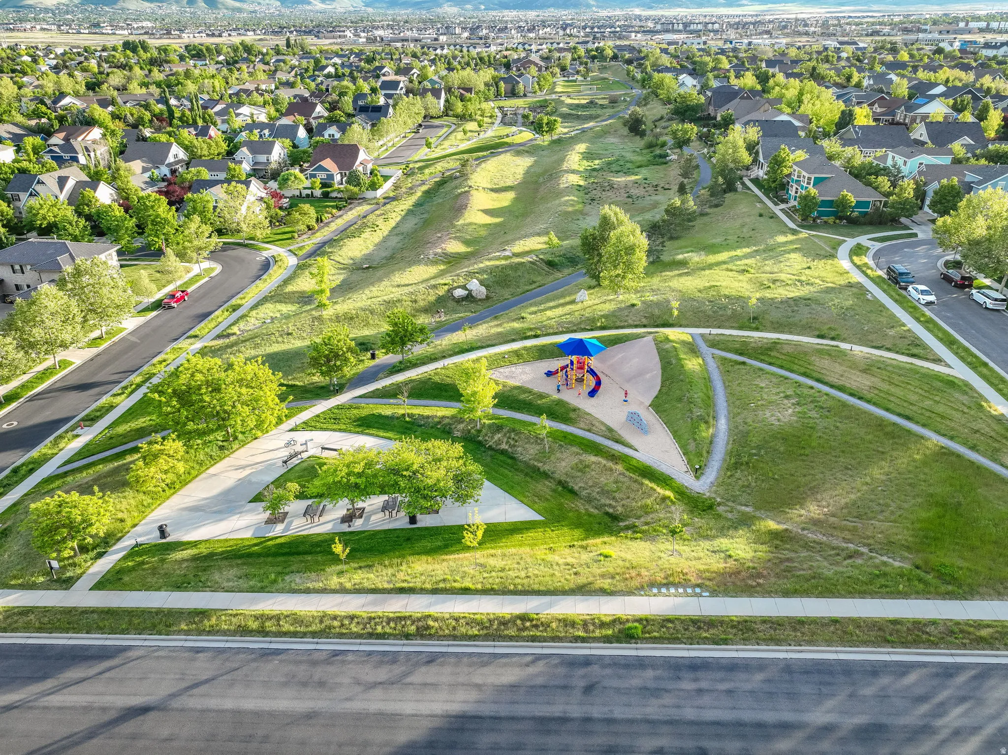 Expansive green spaces featuring walking paths, mature trees, and a dedicated play area